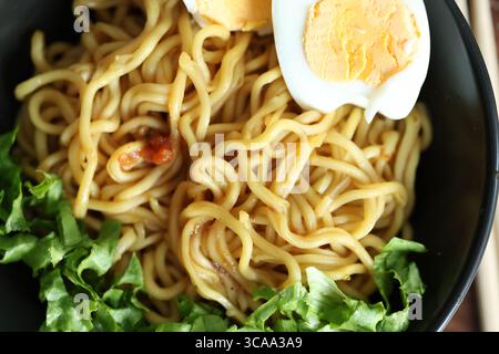 Japanese ramen with egg on black bowl in close-up Stock Photo