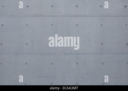 A flat, head-on view of a modern architectural wall made from smooth, gray precast concrete panels. Stock Photo