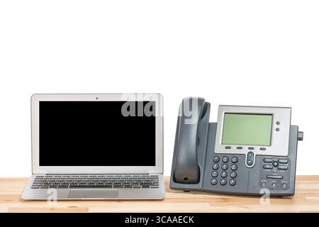 Conceptual workspace or business office concept. Laptop computer with modern IP hone on light wooden table. Isolated background Stock Photo