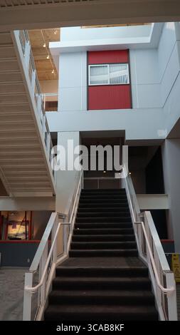 A wide curved staircase inside the California Science Center guides visitors to upper-level exhibits in this modern educational facility in Los Angele Stock Photo