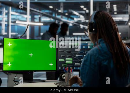 System administrator in server farm using isolated screen PC to repair equipment storing datasets. IT expert using chroma key computer to do debugging on rigs doing computational operations Stock Photo
