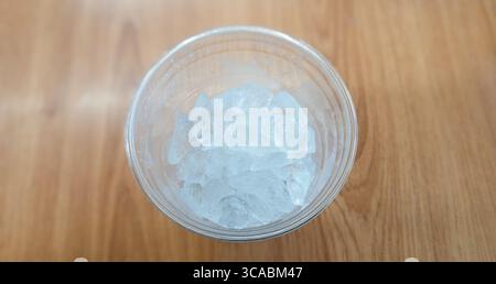 Top View of Ice Cubes in a Transparent Plastic Cup on a Wooden Surface Stock Photo