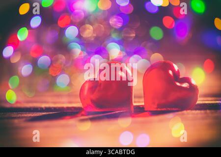 Heart Shape Made of Two Fish Hooks with shadows on wood Stock Photo