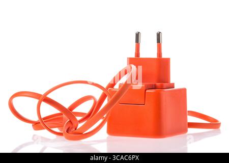 Orange adapter charger with usb cable isolated on white background with reflection. Phone or other electronic device charger Stock Photo
