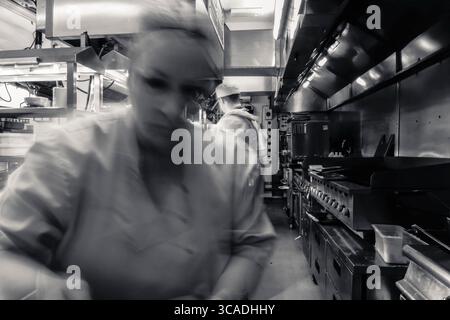 Kitchen action, in a working kitchen. Behind the lines, in the kitchen, long exposure, fast blur, chefs, pub, restaurant, catering, food and beverage Stock Photo