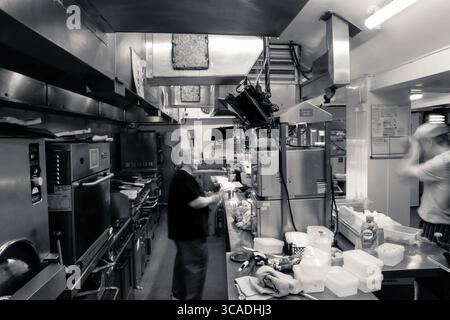 Kitchen action, in a working kitchen. Behind the lines, in the kitchen, long exposure, fast blur, chefs, pub, restaurant, catering, food and beverage Stock Photo