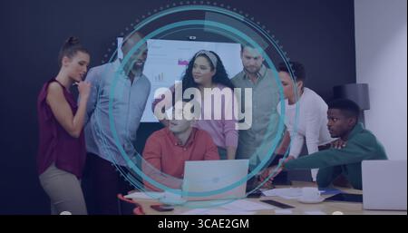 Collaborating team of seven reviewing documents in meeting room, with laptops charts screen Stock Photo