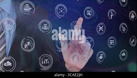 Businessman wearing suit and tie interacting with touch interface in workspace and floating icons Stock Photo