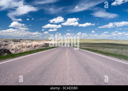 Forced perspective looking down a rural highway to the horizon on the plains of Badlands National Park in South Dakota Stock Photo