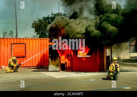 October 5, 2019, Costa Mesa, California: Firemen spray water on a burning model living room in a fire department structural firefighting demonstration in Costa Mesa, CA. (Credit Image: © Spencer Grant/ZUMA Press Wire) Stock Photo