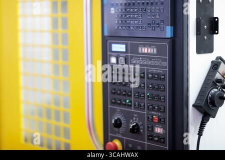 CNC machining center close up. CNC control panel and handheld remote control. Selective focus. Stock Photo