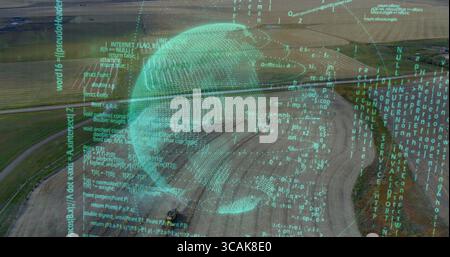 Hovering translucent turquoise digital globe above rural farmland, with streaming code overlay Stock Photo