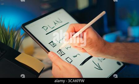 Digital checklist planning productivity goals written by hand on tablet screen using stylus. Concept of task management, goal tracking and project org Stock Photo