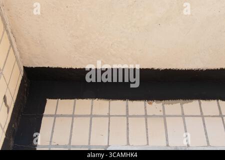External concrete wall panel of the facade and ceiling in a multi-storey panel building, with leak seams sealed with black waterproofing and visible d Stock Photo