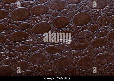 Texture of embossed artificial leather with imitation of oval shapes in brown color as a background for design or upholstery of furniture Stock Photo