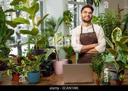 Male shop assistant in the flower shop feeling confident Stock Photo