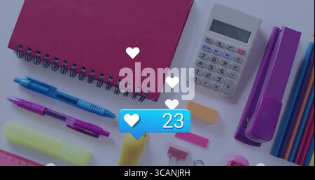 Floating blue like bubble showing 23 likes over flat-lay workspace, with red notebook and pens Stock Photo