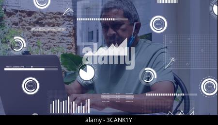 Analyzing senior man using laptop at patio table on metal chair, with coffee mug and plants Stock Photo
