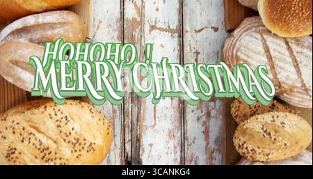 Stylized holiday text spreading cheer on wooden counter, with seeded baguette and assorted breads Stock Photo