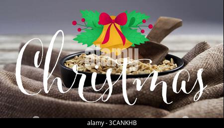 Displaying bowl holding oats with scoop on table featuring cursive Christmas text, holly and bells Stock Photo