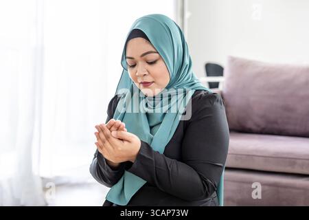 Muslim woman praying at home Stock Photo