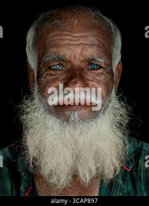 Mirsharai, Bangladesh - 20 September 2020: View of an elderly man with striking light eyes and a long white beard, his weathered face a tapestry of time. Stock Photo