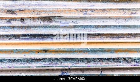 Abstract color-inverted image of rusty industrial pipes with high contrast tones in orange, blue and violet. Creative post-processing. Stock Photo