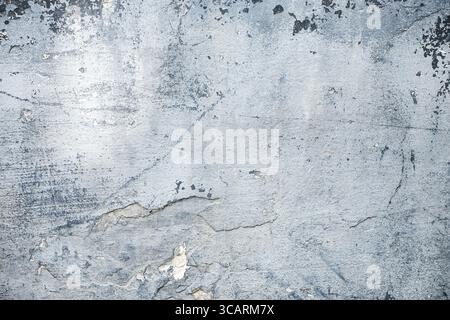 The texture of an old concrete wall with peeling blue paint and traces of time. Stock Photo