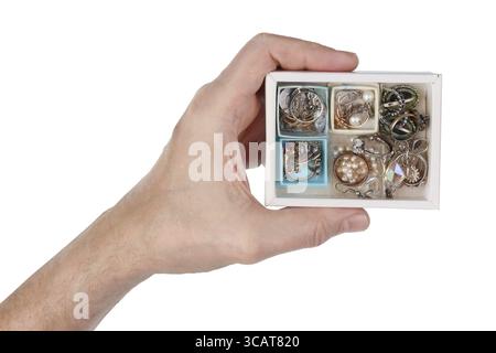 An elderly man holds in his hand a cardboard box with his old wife's jewelry. Mass production. Isolated on white studio macro Stock Photo