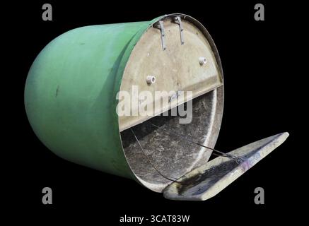 Inverted green plastic trash can with open lid isolated on black Stock Photo
