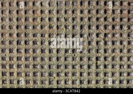 Many handmade square holes in the iron rusty vintage sheet. Vintage metal background Stock Photo