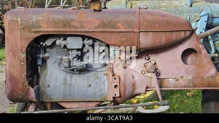 Rusty vintage small tractors diesel engine painted in red Stock Photo