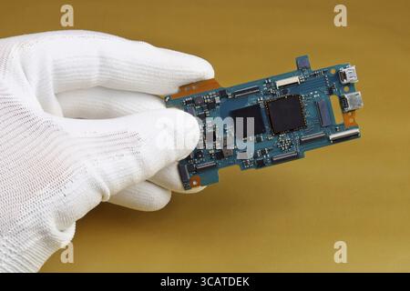 A technician controls the quality of a modern printed circuit board for digital camera. Modern technology macro concept Stock Photo