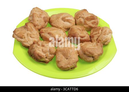 Homemade soft sweet eclairs pastries in rural style on a green plate. Isolated on white studio macro shot Stock Photo