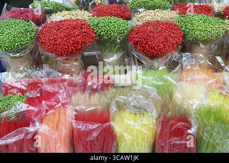 Multicolored paited branches and ears are sold on the street during the spring traditional fair. CLoudy day outdoor shot Stock Photo