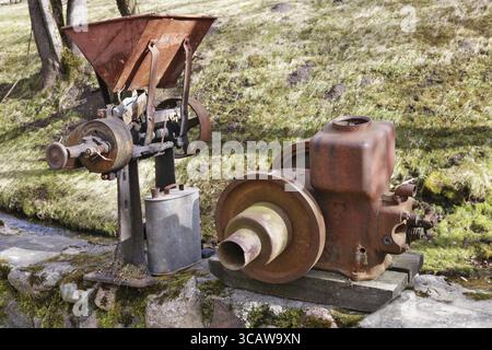 Rusty vintage small tractors diesel engines and retro machinery in village. The metal equipment is made more than hundred years ago. Mass production Stock Photo