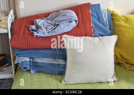My sister's bed is always chaos and mess concept. Blankets and pillows are piled up in one big pile Stock Photo