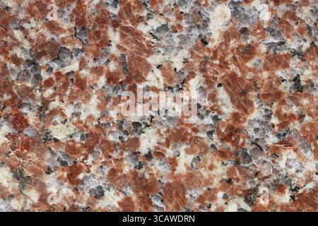 Granular texture of a polished red granite stone Stock Photo