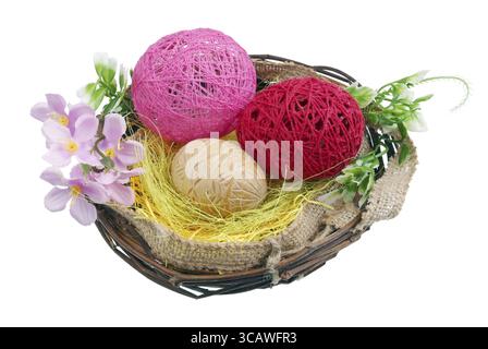 Easter eggs made of wood and thread in a nest of birch twigs Stock Photo