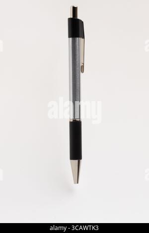 A sleek, modern black and silver retractable ballpoint pen isolated on a clean white background. Stock Photo
