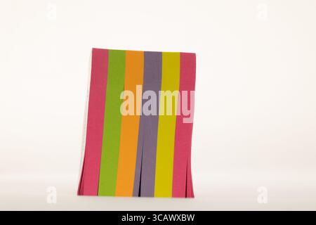 A vibrant and colorful abstract composition featuring vertical stripes of paper in shades of pink, green, orange Stock Photo