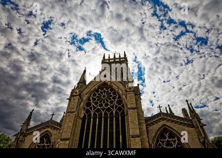 The great East window and tower of Doncaster Minster soar into a dramatic blue and white sky, South Yorkshire, England. Stock Photo