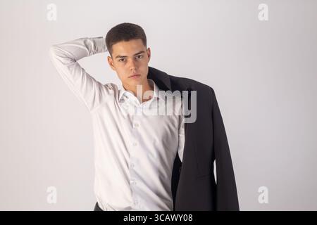 A young man with short, dark hair stands confidently, looking directly at the camera.  Stock Photo