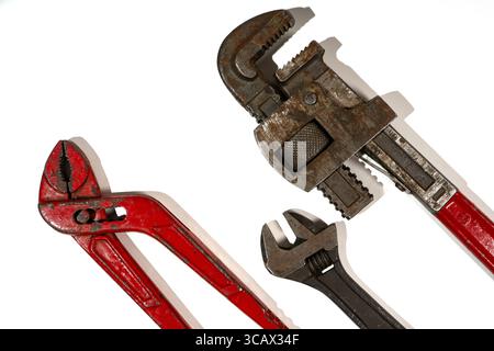 Old rusty and red tools lying on a white background, ready to be used for plumbing work Stock Photo
