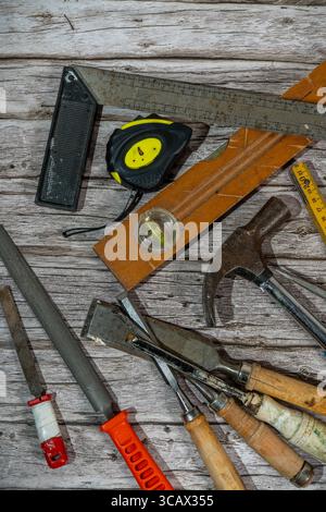 Set of vintage woodworking tools on a weathered wooden workbench, creating a still life of traditional craftsmanship Stock Photo