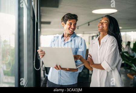 A diverse, talented team collaborates effectively in a bright office space during a business meeting Stock Photo