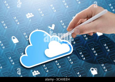 A businessman interacts with a holographic cloud icon surrounded by file icons, representing cloud storage, business database systems, and secure back Stock Photo