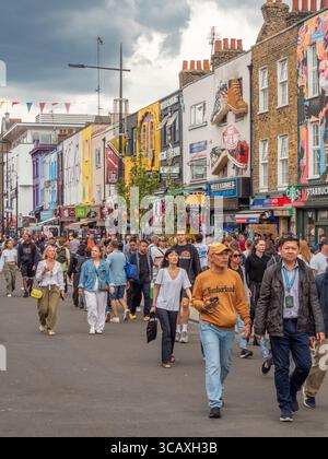A diverse crowd of people exploring the unique shops, including a Starbucks, on the famous Camden High Street in London, UK. Stock Photo