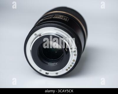 Close-up of a professional camera lens showing the mount and glass elements on a white background Stock Photo