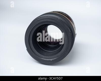 Close-up of a professional camera lens isolated on white background, showcasing detailed glass and textured focus ring Stock Photo